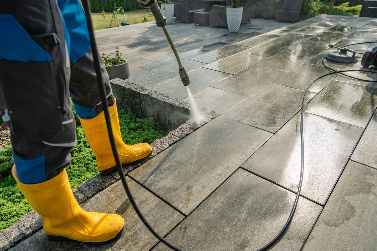 Professional pressure washing a stone patio